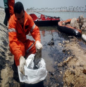 عمال مصريون ينظفون المياه قبالة منتجع الغردقة على البحر الأحمر في أعقاب تسرب نفطي يهدد بإلحاق الضرر بالحياة البحرية